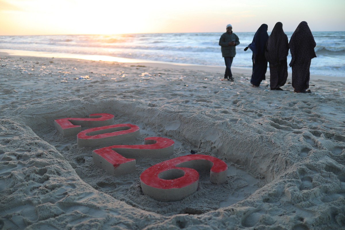 فلسطينيون يودعون عام 2025 بكتابة 2026 على رمال شاطئ غزة، 31 ديسمبركانون الأول 2025. صورة عمر أشتوي