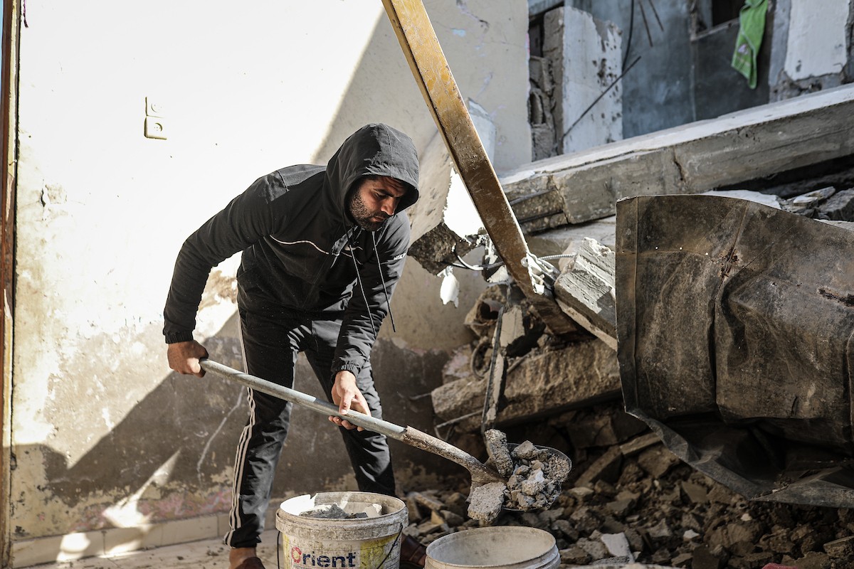 فلسطينيون يتفقدون منزلاً (تضرر سابقاً جراء غارة جوية إسرائيلية) انهار على سكانه، ما أسفر عن وفاة رجل ونجله الصغير في مخيم المغازي للاجئين وسط قطاع غزة، 5 يناير/كانون الثاني 2026. صورة: رمزي أبو عامر