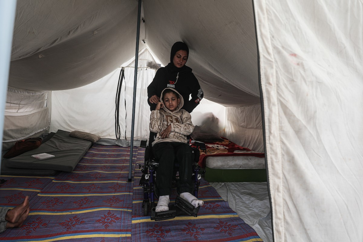 الطفل سيف رامي حجازي (13 عاما) أُصيب بشلل كامل وفشل كلوي إثر قصف إسرائيلي لخيمة عائلته، وتتولى والدته رعايته في ظروف إنسانية بالغة الصعوبة بمخيم المغازي، وسط قطاع غزة، 30 يناير/كانون الثاني 2026. صورة: معز صالحي