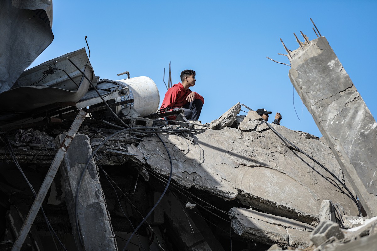 فلسطينيون يتفقدون منزلاً (تضرر سابقاً جراء غارة جوية إسرائيلية) انهار على سكانه، ما أسفر عن وفاة رجل ونجله الصغير في مخيم المغازي للاجئين وسط قطاع غزة، 5 يناير/كانون الثاني 2026. صورة: رمزي أبو عامر