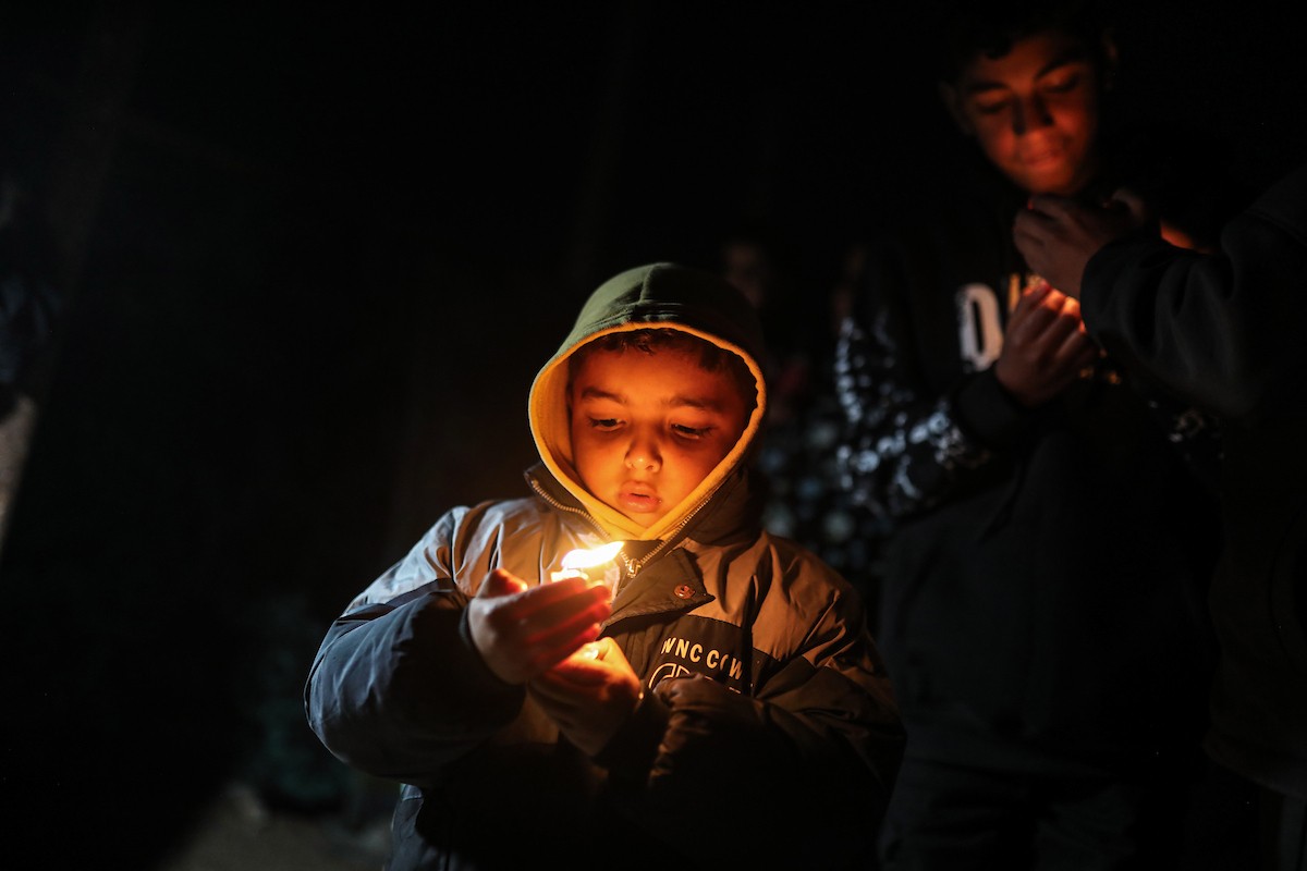 أطفال في وقفة احتجاجية في مخيم الشاطئ غرب مدينة غزة ليلة رأس السنة الميلادية 2026، 1 يناير/كانون الثاني 2026. تصوير: عمر أشتوي