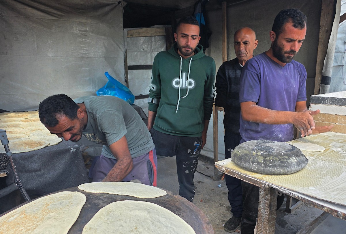 الفلسطيني محمد قحمان يعيد افتتاح مخبز تقليدي وسط أنقاض مدينة حمد غرب خان يونس، ويعمل جنباً إلى جنب مع أبنائه وصهره، وجميعهم من مبتوري الأطراف، 21 يناير/كانون الثاني 2026  . صورة: طارق محمد