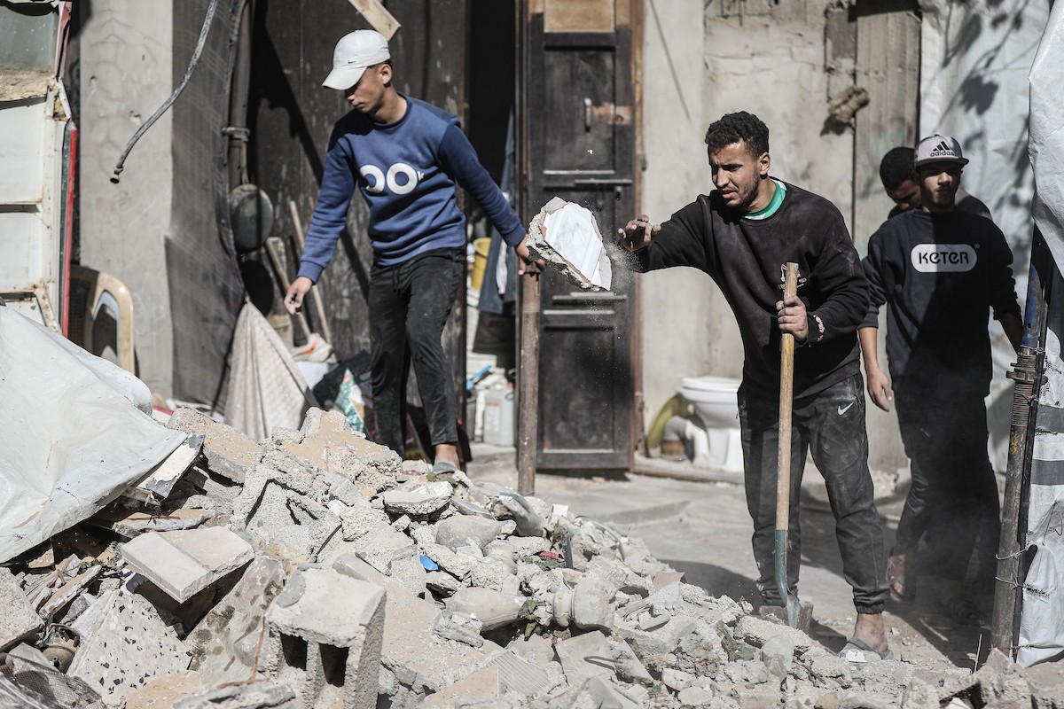فلسطينيون يتفقدون منزلاً (تضرر سابقاً جراء غارة جوية إسرائيلية) انهار على سكانه، ما أسفر عن وفاة رجل ونجله الصغير في مخيم المغازي للاجئين وسط قطاع غزة، 5 يناير/كانون الثاني 2026. صورة: رمزي أبو عامر