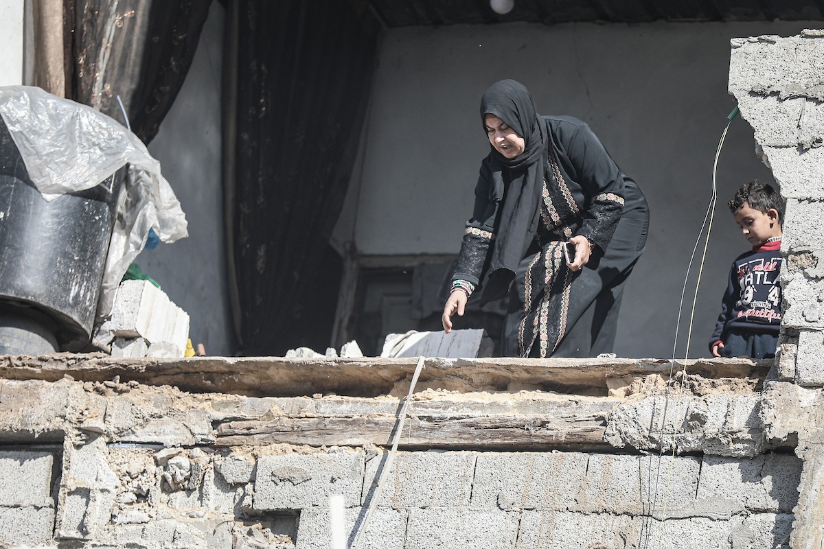 فلسطينيون يتفقدون منزلاً (تضرر سابقاً جراء غارة جوية إسرائيلية) انهار على سكانه، ما أسفر عن وفاة رجل ونجله الصغير في مخيم المغازي للاجئين وسط قطاع غزة، 5 يناير/كانون الثاني 2026. صورة: رمزي أبو عامر
