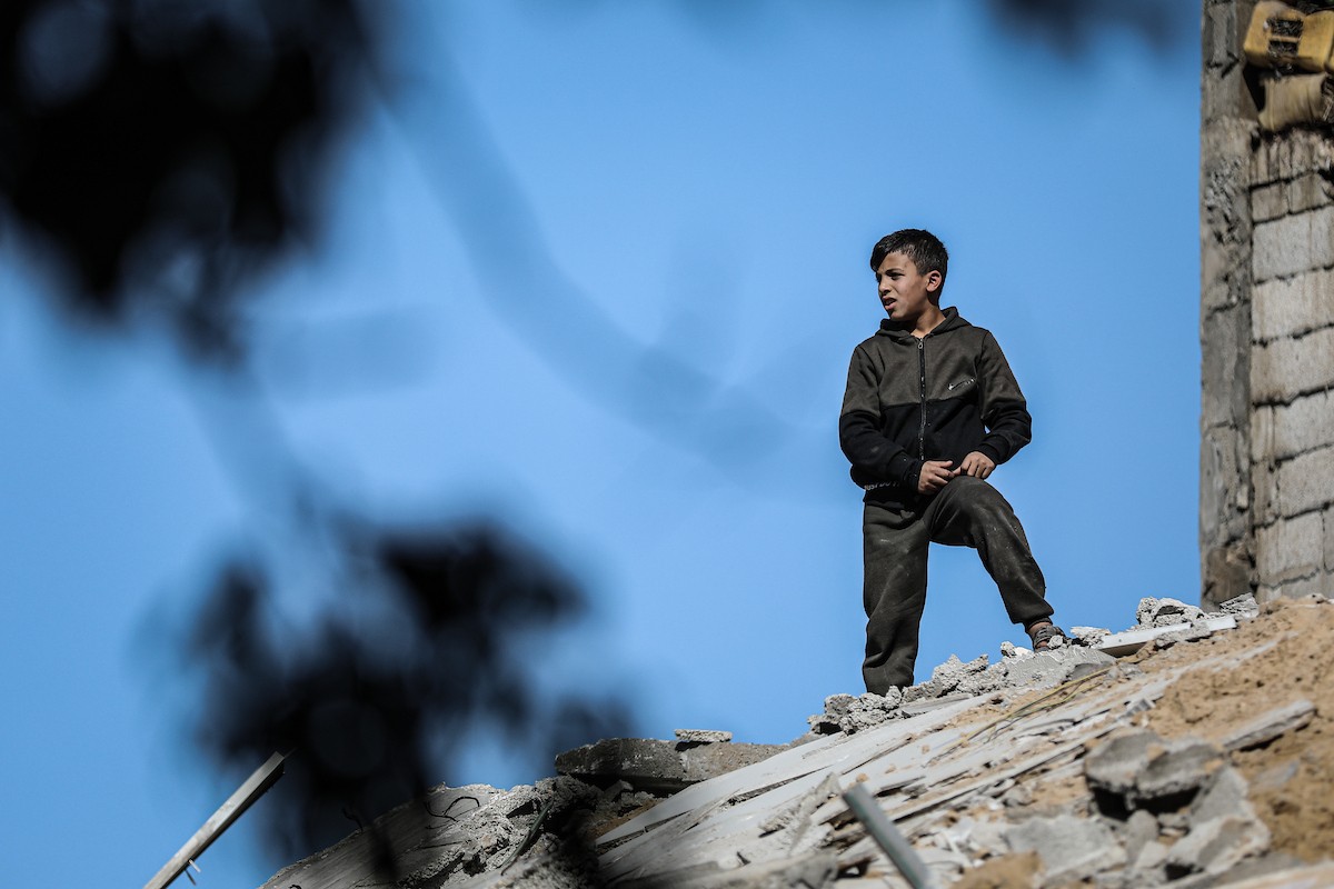 فلسطينيون يتفقدون منزلاً (تضرر سابقاً جراء غارة جوية إسرائيلية) انهار على سكانه، ما أسفر عن وفاة رجل ونجله الصغير في مخيم المغازي للاجئين وسط قطاع غزة، 5 يناير/كانون الثاني 2026. صورة: رمزي أبو عامر