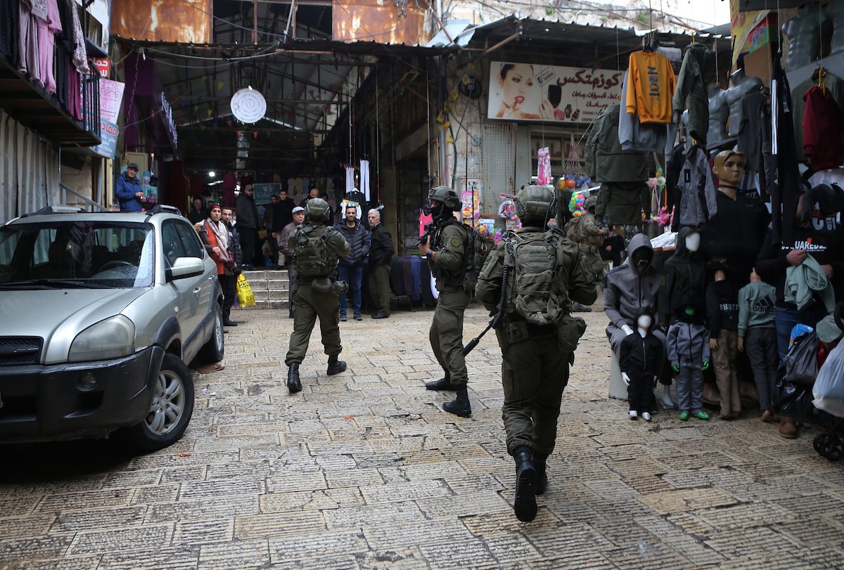 القوات الإسرائيلية تداهم عدد من المحال التجارية في السوق المركزي وتطلق النار تجاه بناية سكنية، وتوقف عدد من المواطنين في البلدة القديمة بمدينة نابلس، 1 يناير/كانون الثاني ٢٠٢٦. صورة: محمد ناصر