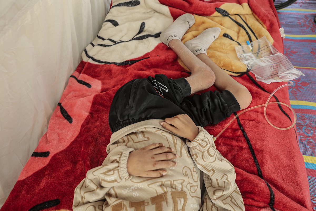 الطفل سيف رامي حجازي (13 عاما) أُصيب بشلل كامل وفشل كلوي إثر قصف إسرائيلي لخيمة عائلته، وتتولى والدته رعايته في ظروف إنسانية بالغة الصعوبة بمخيم المغازي، وسط قطاع غزة، 30 يناير/كانون الثاني 2026. صورة: معز صالحي