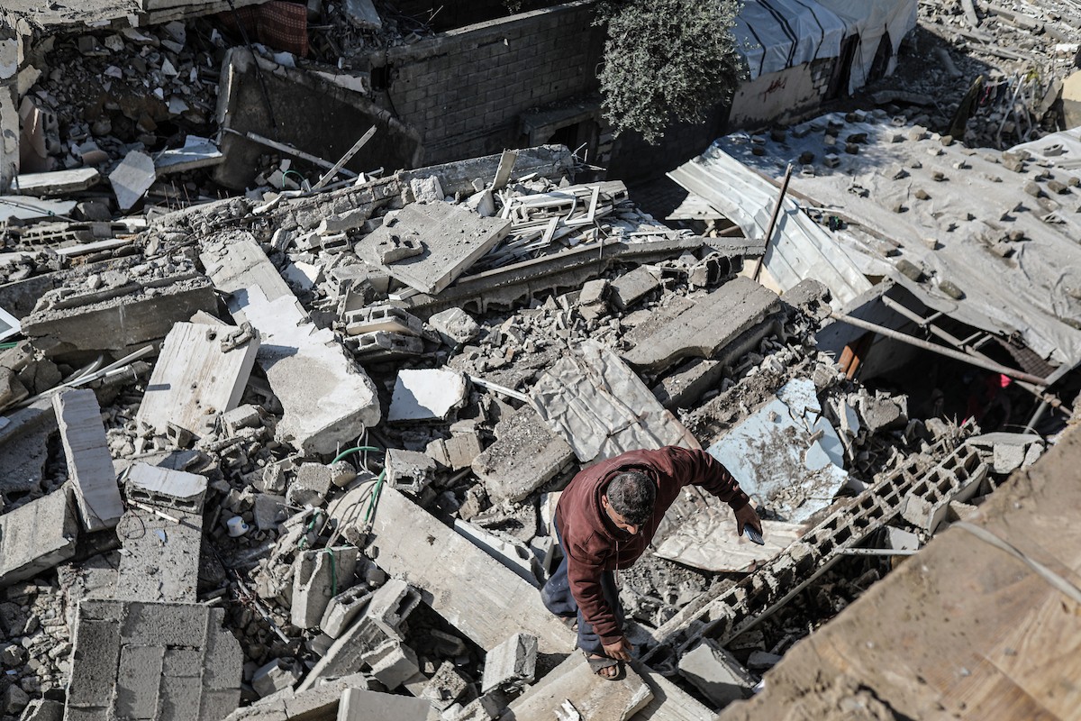 فلسطينيون يتفقدون منزلاً (تضرر سابقاً جراء غارة جوية إسرائيلية) انهار على سكانه، ما أسفر عن وفاة رجل ونجله الصغير في مخيم المغازي للاجئين وسط قطاع غزة، 5 يناير/كانون الثاني 2026. صورة: رمزي أبو عامر
