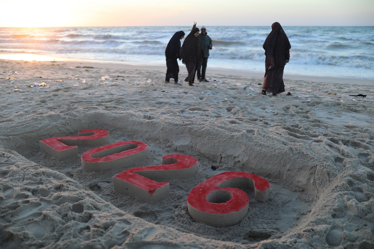 فلسطينيون يودعون عام 2025 بكتابة 2026 على رمال شاطئ غزة، 31 ديسمبركانون الأول 2025. صورة عمر أشتوي