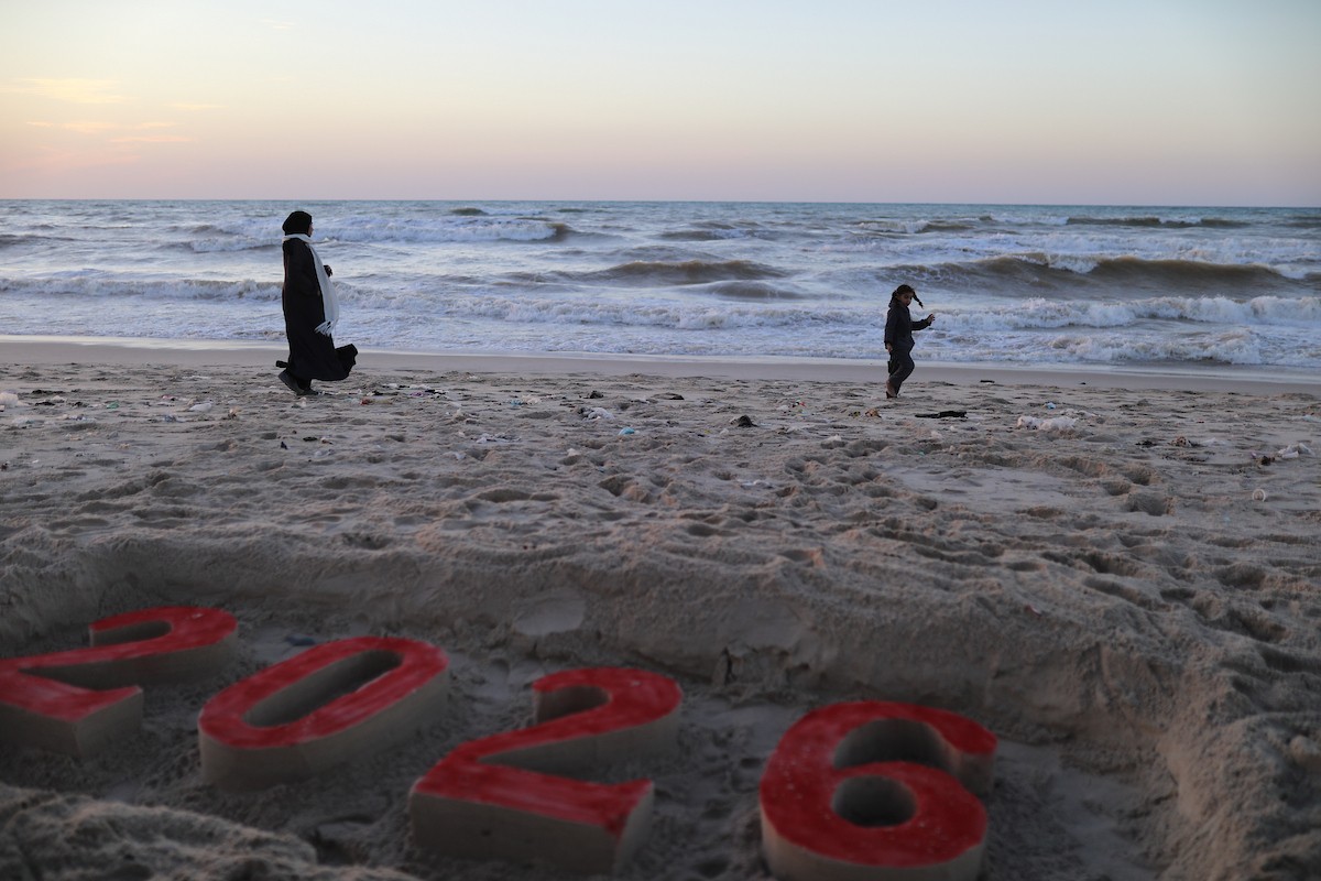 فلسطينيون يودعون عام 2025 بكتابة 2026 على رمال شاطئ غزة، 31 ديسمبركانون الأول 2025. صورة عمر أشتوي