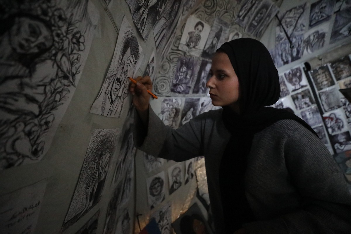 الفلسطينية مرَح خالد الزعانين (18 عاما) تحول خيمة نزوحها في مدينة غزة إلى معرض فني، 28 يناير/كانون الثاني 2026. تصوير: عمر أشتوي