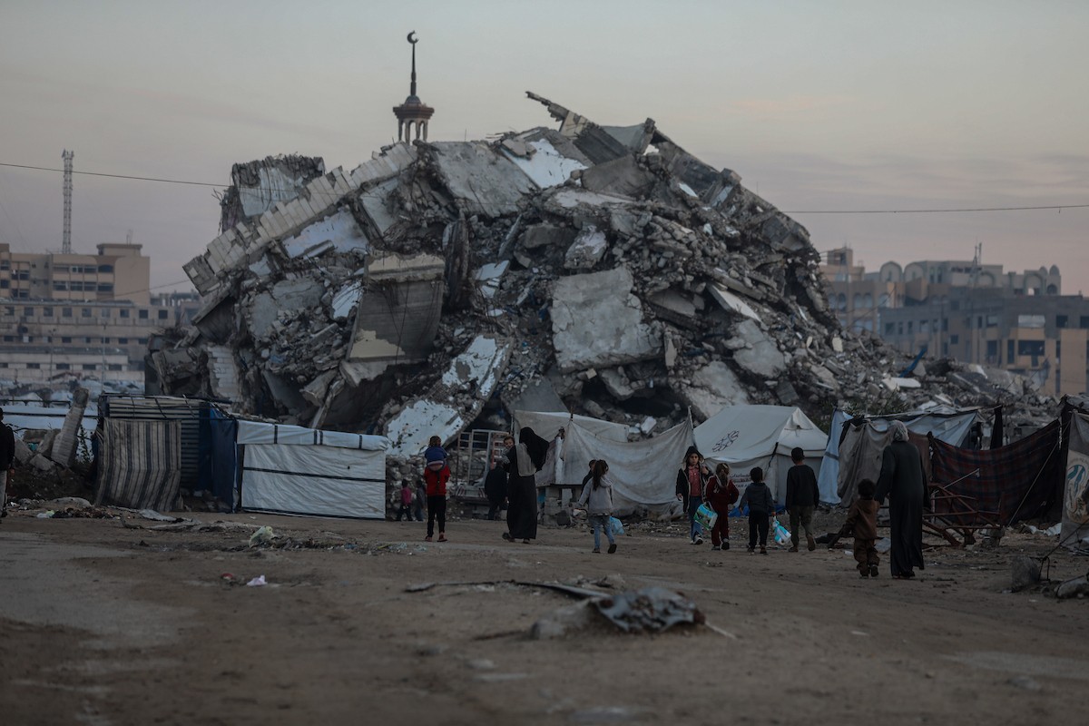 يسير فلسطينيون في شوارع مدينة غزة، وسط الأنقاض والدمار الذي خلفه الصراع الدائر، في 10 يناير/كانون الثاني 2026، بينما تستمر الحياة اليومية في ظل ظروف صعبة. صورة: عمر أشتوي