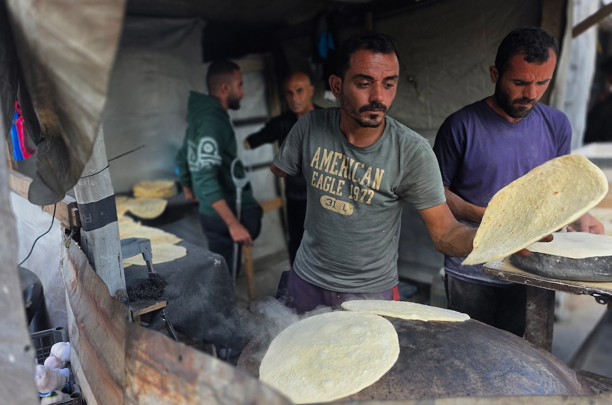 الفلسطيني محمد قحمان يعيد افتتاح مخبز تقليدي وسط أنقاض مدينة حمد غرب خان يونس، ويعمل جنباً إلى جنب مع أبنائه وصهره، وجميعهم من مبتوري الأطراف، 21 يناير/كانون الثاني 2026  . صورة: طارق محمد