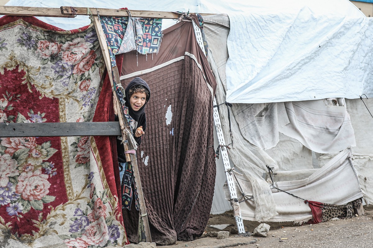 تواصل العائلات الفلسطينية النازحة المقيمة في مخيم الزوايدة وسط قطاع غزة حياتها اليومية في ظل ظروف قاسية داخل خيام متهالكة لا توفر أي حماية أو دفء من برد الشتاء القارس، 18 يناير/كانون الثاني 2026. صورة: رمزي أبو عامر