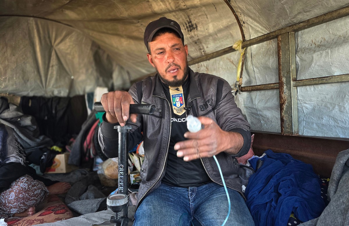 يعيش الفلسطيني سامي أبو سعادة مع والدته داخل عربة جرار، ويستخدم مضخة نفخ مطاطية لمساعدة والدته التي تعاني من صعوبة في التنفس. خان يونس، جنوب قطاع غزة، 7 يناير/كانون الثاني 2026، صورة: طارق محمد