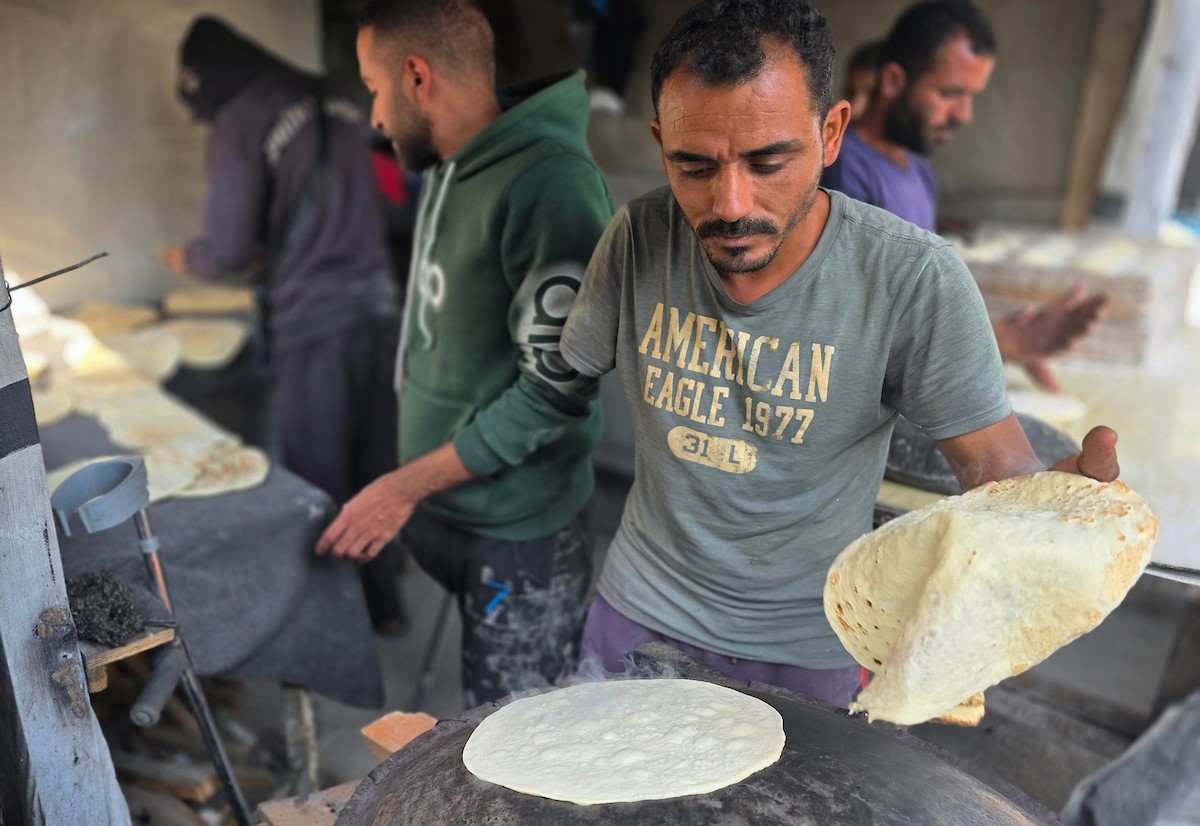 الفلسطيني محمد قحمان يعيد افتتاح مخبز تقليدي وسط أنقاض مدينة حمد غرب خان يونس، ويعمل جنباً إلى جنب مع أبنائه وصهره، وجميعهم من مبتوري الأطراف، 21 يناير/كانون الثاني 2026  . صورة: طارق محمد