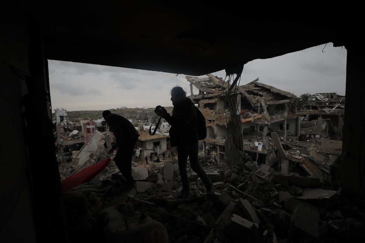 يبحث فلسطينيون عن ممتلكاتهم بين الأنقاض بعد أن دمرت غارات جوية إسرائيلية مبنى في مخيم البريج للاجئين وسط قطاع غزة. دمر الهجوم المبنى بالكامل وألحق أضرارًا بالمنشآت المحيطة به، 9 يناير/كانون الثاني 2026. صورة: معز صالحي