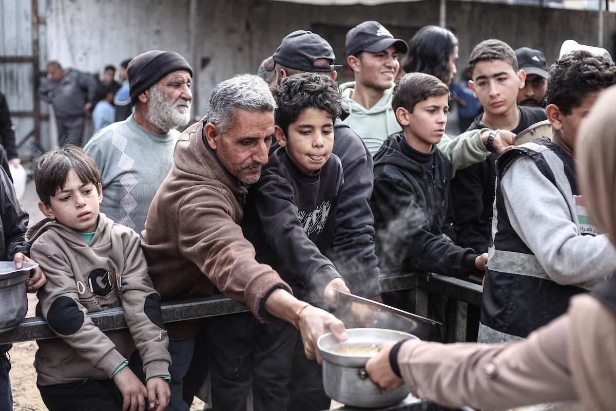 تلقى فلسطينيون، بينهم أطفال، وجبات ساخنة وزعتها إحدى الجمعيات الخيرية في مخيم النصيرات للاجئين، وسط نقص حاد في الغذاء ناجم عن الهجمات الإسرائيلية المستمرة وتدهور الأوضاع الإنسانية. النصيرات، وسط قطاع غزة. 26 يناير/كانون الثاني 2026. تصوير: معز صالحي