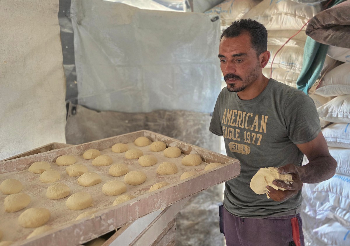 الفلسطيني محمد قحمان يعيد افتتاح مخبز تقليدي وسط أنقاض مدينة حمد غرب خان يونس، ويعمل جنباً إلى جنب مع أبنائه وصهره، وجميعهم من مبتوري الأطراف، 21 يناير/كانون الثاني 2026  . صورة: طارق محمد