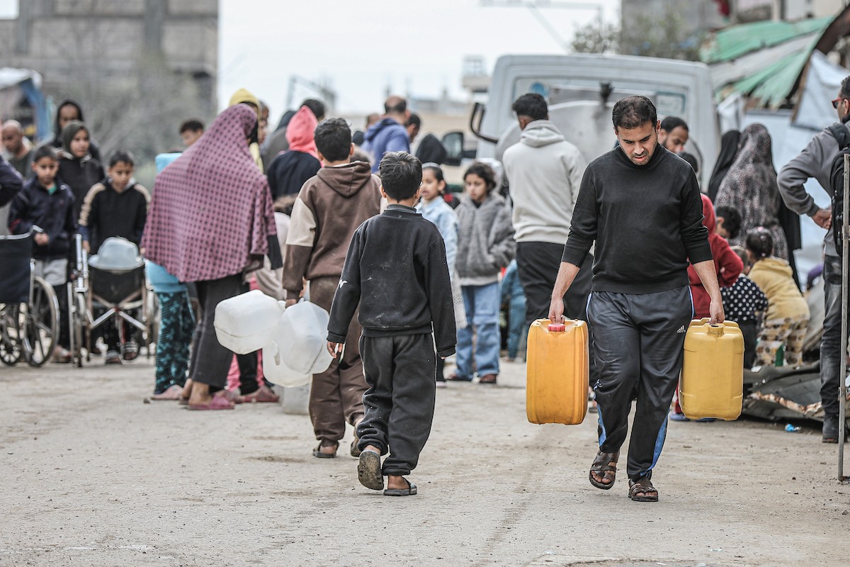 يملأ الفلسطينيون خزاناتهم بالمياه التي توزعها صهاريج المياه، وينقلونها إلى خيامهم في مخيم النصيرات وسط قطاع غزة، حيث تفاقمت أزمة المياه نتيجة الأضرار الجسيمة التي لحقت بالبنية التحتية جراء الهجمات الإسرائيلية، 29 يناير/كانون الثاني 2026. صورة: رمزي أبو عامر