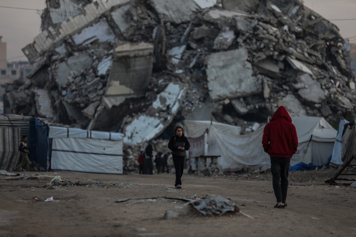 يسير فلسطينيون في شوارع مدينة غزة، وسط الأنقاض والدمار الذي خلفه الصراع الدائر، في 10 يناير/كانون الثاني 2026، بينما تستمر الحياة اليومية في ظل ظروف صعبة. صورة: عمر أشتوي