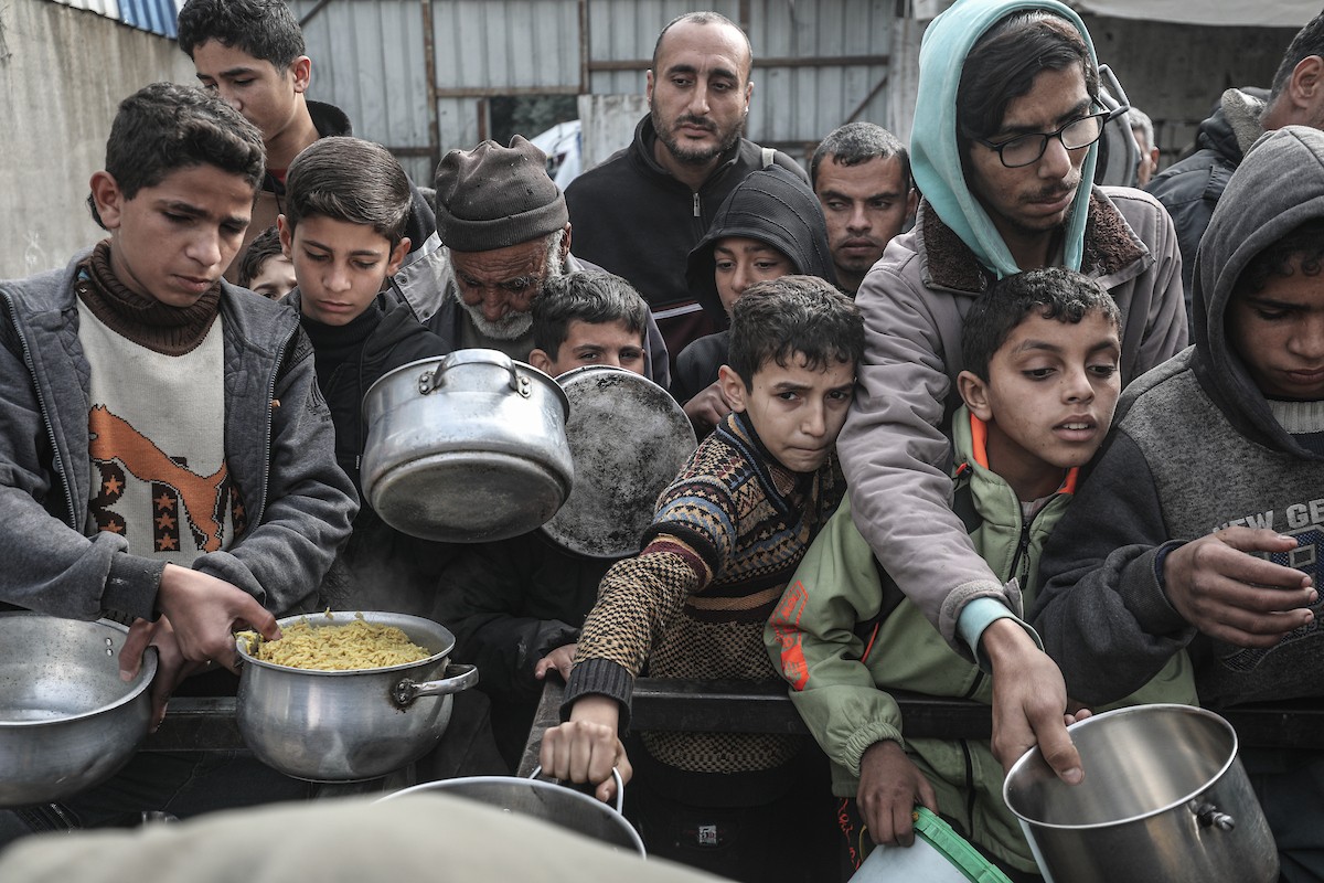 تجمع فلسطينيون نازحون داخلياً في مطبخ خيري لتلقي حصص غذائية محدودة وسط نقص حاد في الغذاء، في مخيم النصيرات للاجئين وسط قطاع غزة، 21 يناير/كانون الثاني 2026. صورة: معز صالحي
