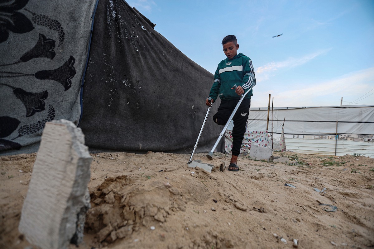 الطفل عمر حلاوة (13عاما) يزور مكان دفن ساقه المبتور يوميا، بعد إصابته في غارة إسرائيلية خلال الحرب على غزة، 31 ديسمبر/كانون الأول 2025. تصوير: عمر أشتوي