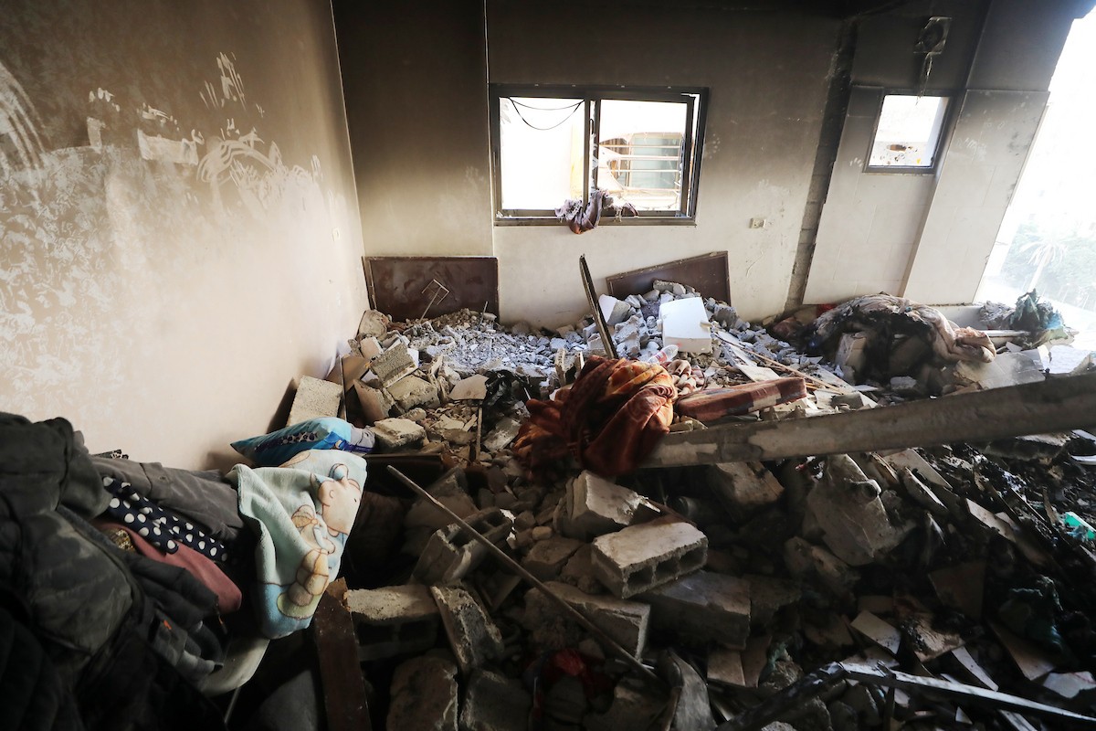 فلسطينيون يمرون أمام مبنى سكني تضرر جراء غارة عسكرية إسرائيلية أسفرت عن سقوط عدد من الضحايا في مدينة غزة، السبت 31 يناير/كانون الثاني 2026. صورة: عمر أشتوي