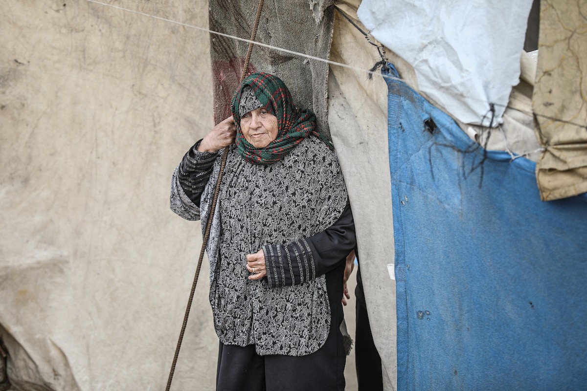 يتفقد فلسطينيون نازحون خيامهم بعد أن تضررت بشدة جراء عاصفة هوائية قوية ضربت مخيمًا للنازحين وسط قطاع غزة. 22 يناير/كانون الثاني 2026. تصوير: رمزي أبو عامر