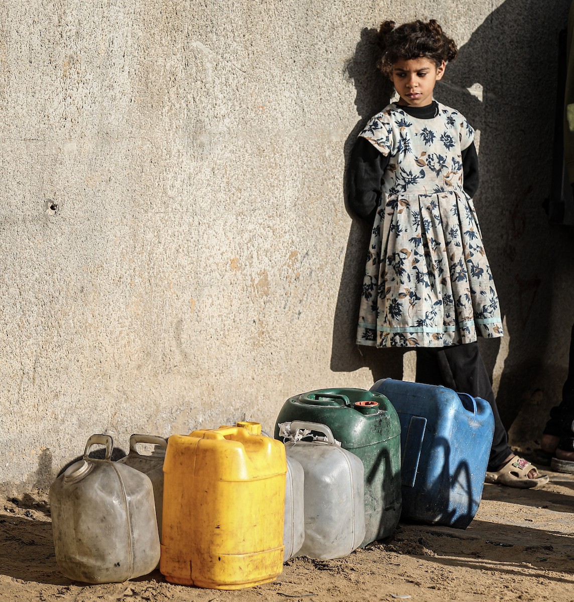 يملأ الفلسطينيون جالوناتهم بالمياه التي توزعها صهاريج المياه، وينقلونها إلى خيامهم في مخيم النصيرات، حيث تفاقمت أزمة المياه نتيجة الأضرار الجسيمة التي لحقت بالبنية التحتية جراء الهجمات الإسرائيلية. النصيرات، وسط قطاع غزة، 29 يناير/كانون الثاني 2026. صورة: رمزي أبو عامر