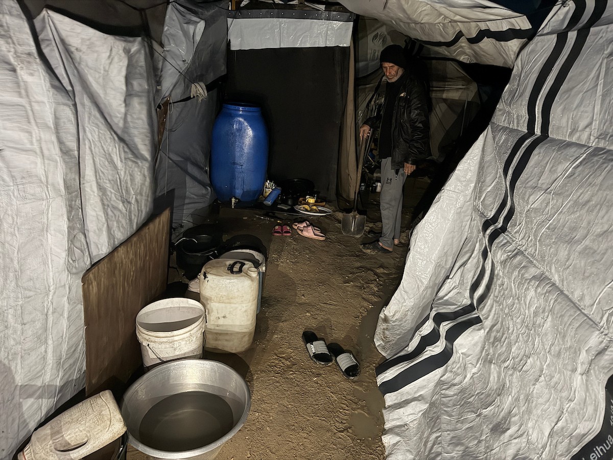 يُكافح الفلسطينيون النازحون، الذين يعيشون في خيام مؤقتة، من أجل البقاء في ظل ظروف قاسية ومعاناة متفاقمة، حيث اقتلعت الأمطار الغزيرة والعواصف العديد من خيامهم وأغرقتها في مدينة خان يونس جنوب قطاع غزة. 9 يناير/كانون الثاني 2026. صورة: محمد سلامة