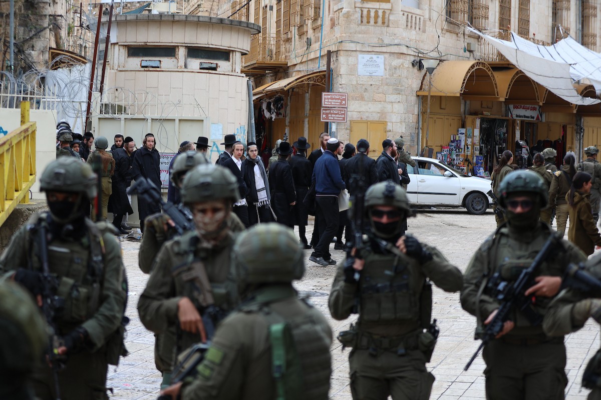 جنود إسرائيليون يقفون في دورية حراسة خلال جولة أسبوعية للمستوطنين في مدينة الخليل، جنوب الضفة الغربية ، 10 يناير/كانون الثاني 2026. تصوير: مأمون وزواز