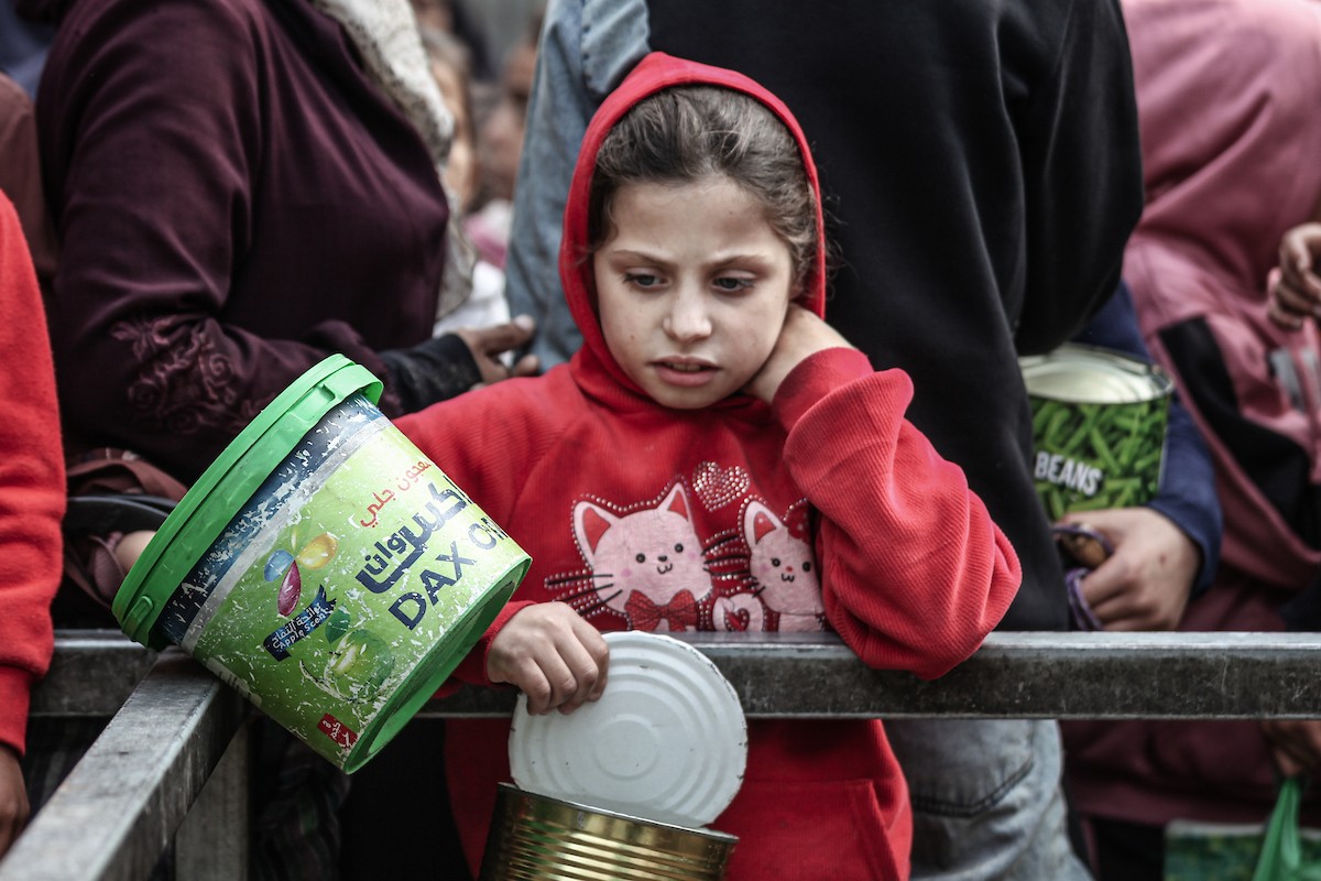 أطفال فلسطينيون ينتظرون وجبة ساخنة، توزعها إحدى المنظمات الخيرية، في ظل استمرار أزمة الغذاء بسبب محدودية المساعدات الإنسانية في مخيم النصيرات للاجئين وسط قطاع غزة، في 10 يناير/كانون الثاني 2026. صورة: معز صالحي