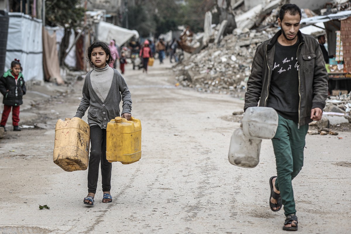 يملأ الفلسطينيون خزاناتهم بالمياه التي توزعها صهاريج المياه، وينقلونها إلى خيامهم في مخيم النصيرات وسط قطاع غزة، حيث تفاقمت أزمة المياه نتيجة الأضرار الجسيمة التي لحقت بالبنية التحتية جراء الهجمات الإسرائيلية، 29 يناير/كانون الثاني 2026. صورة: رمزي أبو عامر