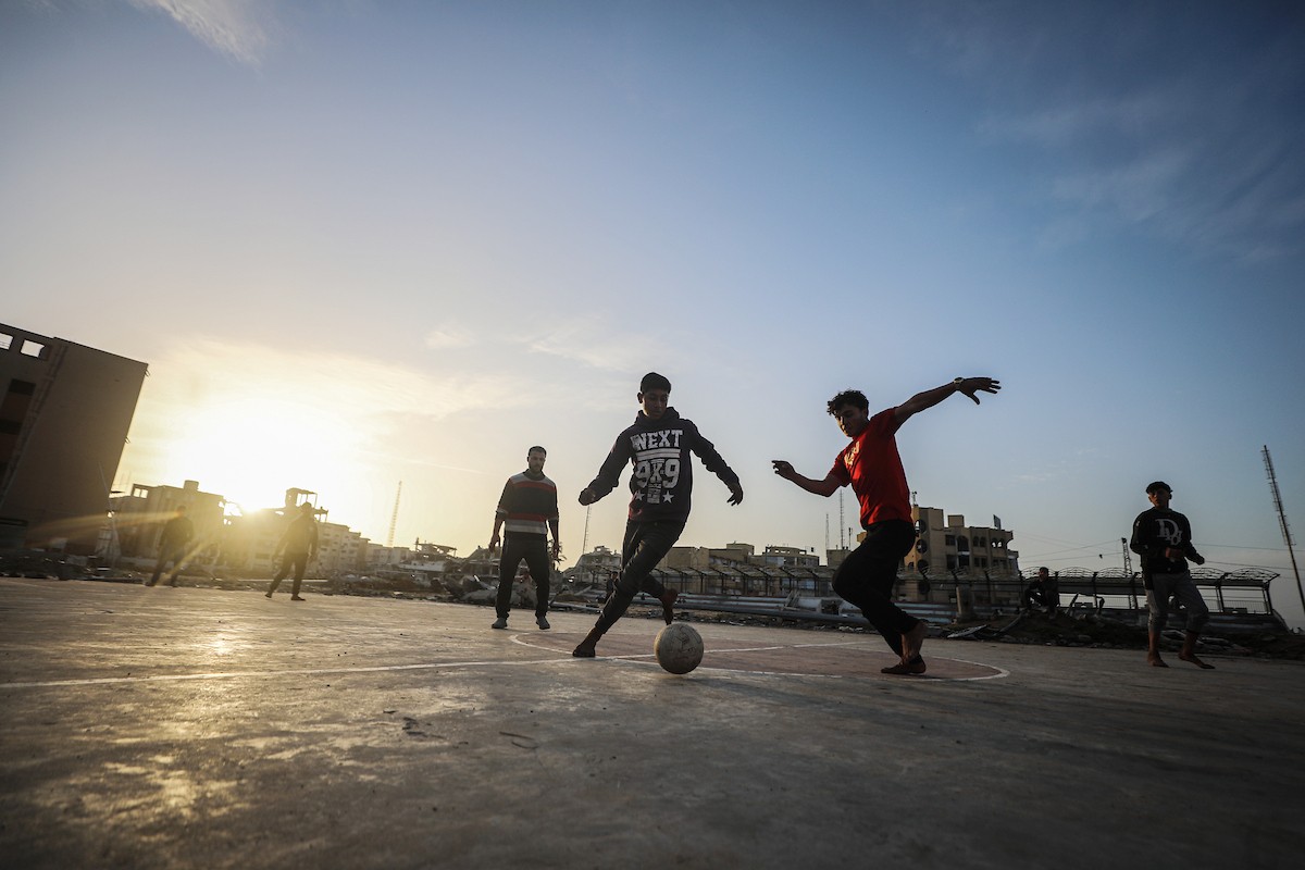   شبان فلسطينيون نازحون يلعبون كرة القدم في ملعب مدمر بمدينة غزة، في 10 يناير/كانون الثاني 2026. صورة: عمر أشتوي