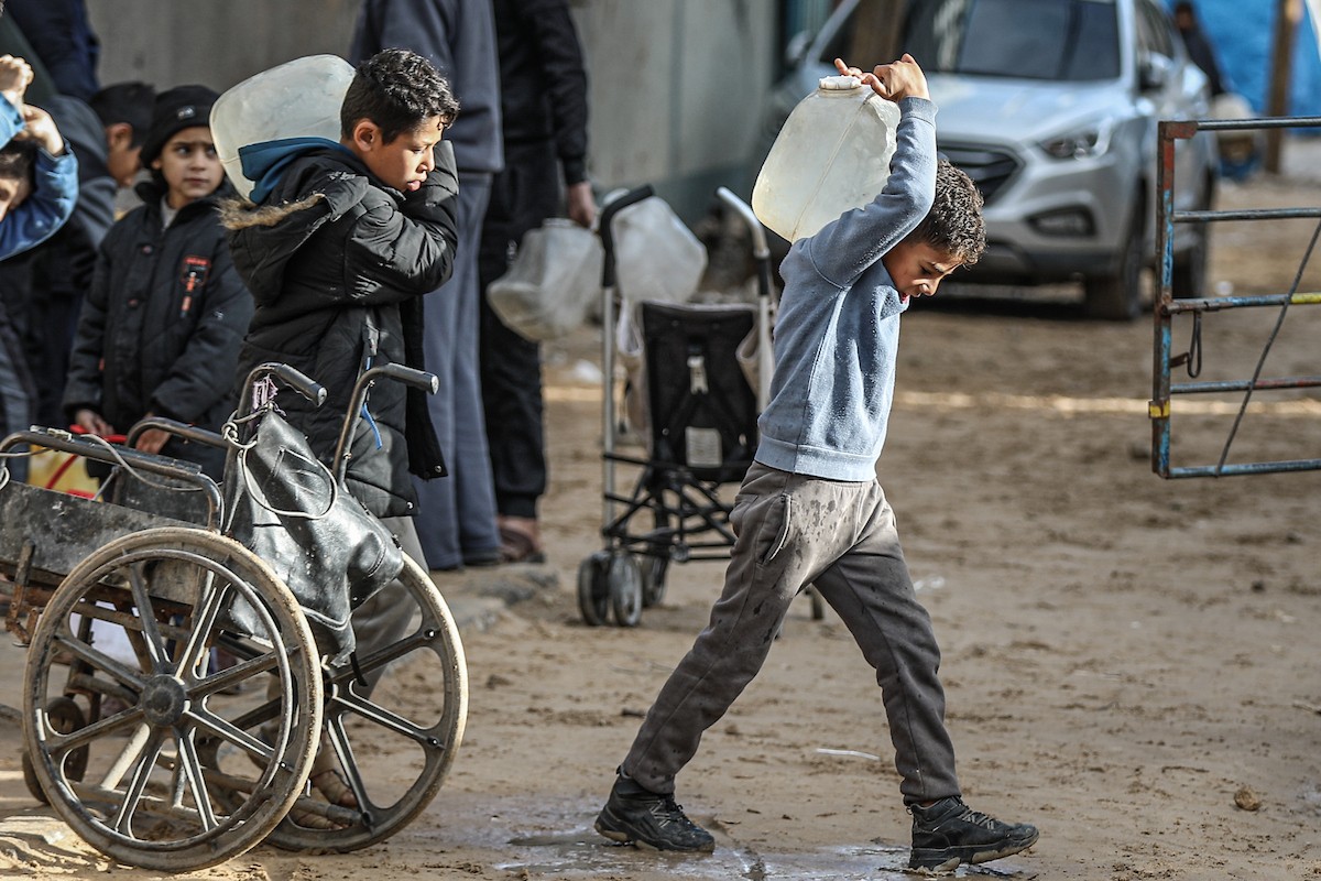 يملأ الفلسطينيون خزاناتهم بالمياه التي توزعها صهاريج المياه، وينقلونها إلى خيامهم في مخيم النصيرات وسط قطاع غزة، حيث تفاقمت أزمة المياه نتيجة الأضرار الجسيمة التي لحقت بالبنية التحتية جراء الهجمات الإسرائيلية، 29 يناير/كانون الثاني 2026. صورة: رمزي أبو عامر