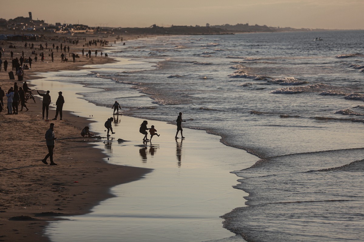 يقضي الفلسطينيون أوقاتهم على شاطئ البحر عند غروب الشمس في مدينة غزة، 16 يناير/كانون الثاني 2026. تصوير: عمر أشتوي