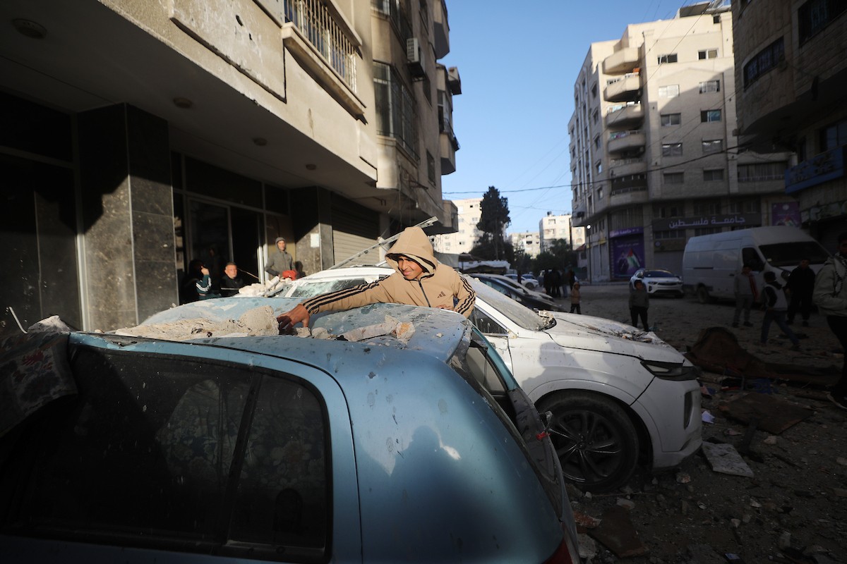 فلسطينيون يمرون أمام مبنى سكني تضرر جراء غارة عسكرية إسرائيلية أسفرت عن سقوط عدد من الضحايا في مدينة غزة، السبت 31 يناير/كانون الثاني 2026. صورة: عمر أشتوي