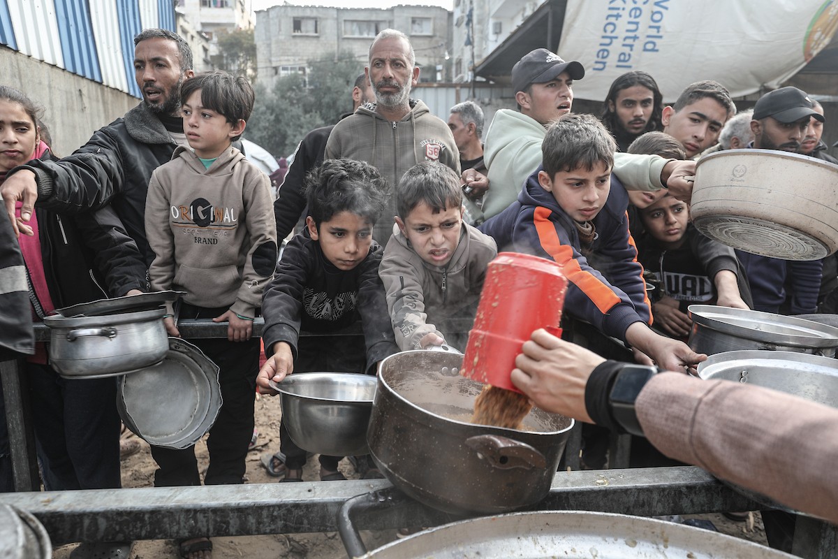 تلقى فلسطينيون، بينهم أطفال، وجبات ساخنة وزعتها إحدى الجمعيات الخيرية في مخيم النصيرات للاجئين، وسط نقص حاد في الغذاء ناجم عن الهجمات الإسرائيلية المستمرة وتدهور الأوضاع الإنسانية. النصيرات، وسط قطاع غزة. 26 يناير/كانون الثاني 2026. تصوير: معز صالحي