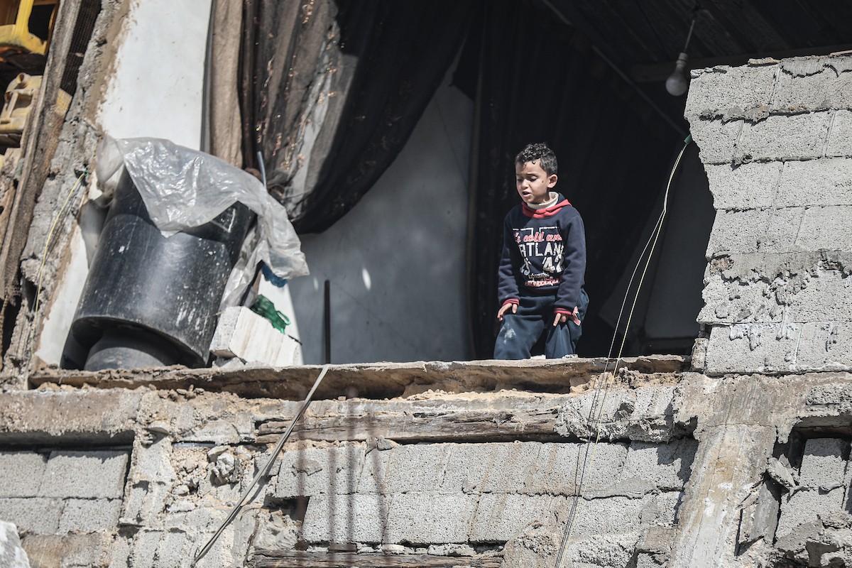 فلسطينيون يتفقدون منزلاً (تضرر سابقاً جراء غارة جوية إسرائيلية) انهار على سكانه، ما أسفر عن وفاة رجل ونجله الصغير في مخيم المغازي للاجئين وسط قطاع غزة، 5 يناير/كانون الثاني 2026. صورة: رمزي أبو عامر
