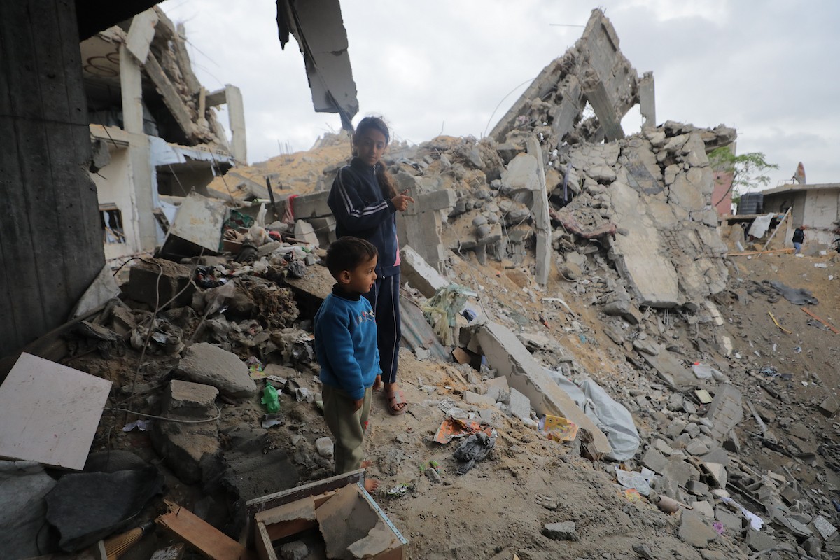 يبحث فلسطينيون عن ممتلكاتهم بين الأنقاض بعد أن دمرت غارات جوية إسرائيلية مبنى في مخيم البريج للاجئين وسط قطاع غزة. دمر الهجوم المبنى بالكامل وألحق أضرارًا بالمنشآت المحيطة به، 9 يناير/كانون الثاني 2026. صورة: معز صالحي