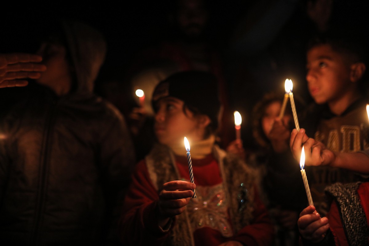 أطفال في وقفة احتجاجية في مخيم الشاطئ غرب مدينة غزة ليلة رأس السنة الميلادية 2026، 1 يناير/كانون الثاني 2026. تصوير: عمر أشتوي