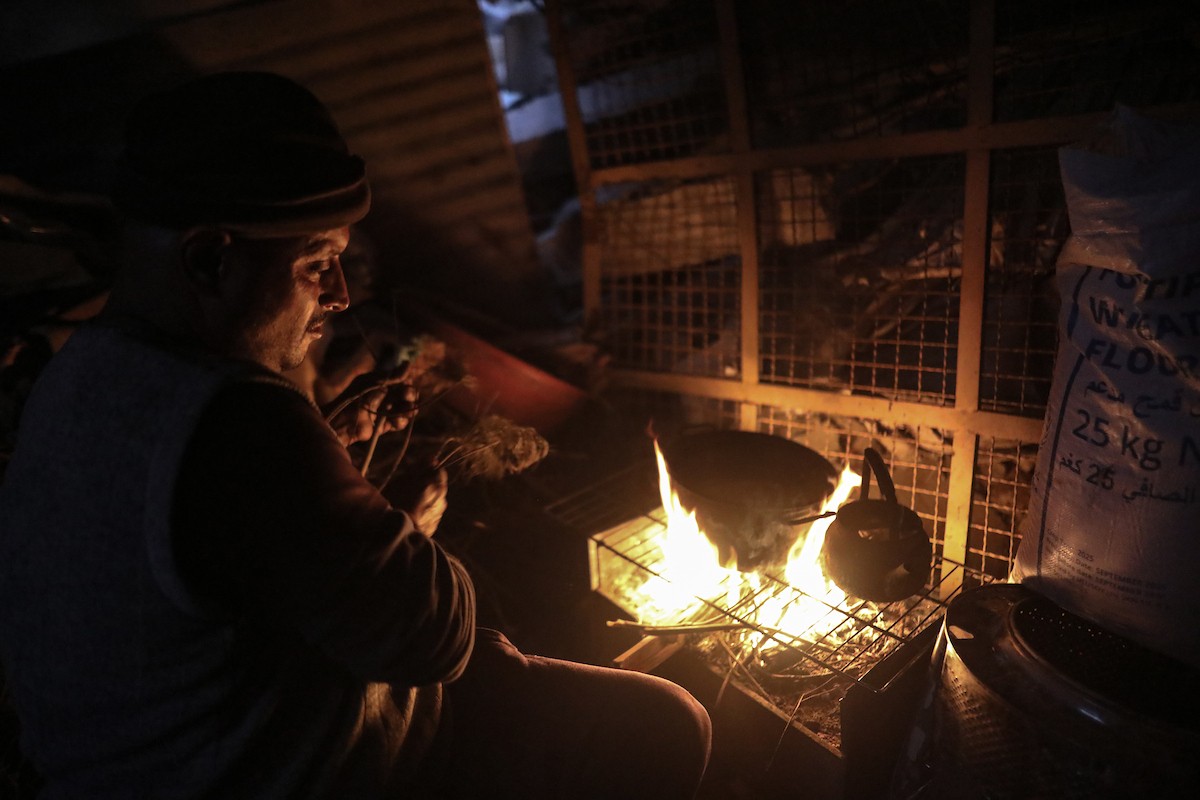 عائلات تعيش في خيام مؤقتة وسط الأنقاض تشعل نيرانًا للتدفئة في جباليا، شمال قطاع غزة، في 12 يناير/كانون الثاني 2026. ويكافح الفلسطينيون الذين دُمرت منازلهم في هجمات إسرائيلية من أجل البقاء في ظل ظروف شتوية قاسية وبرد قارس. صورة: عمر أشتوي