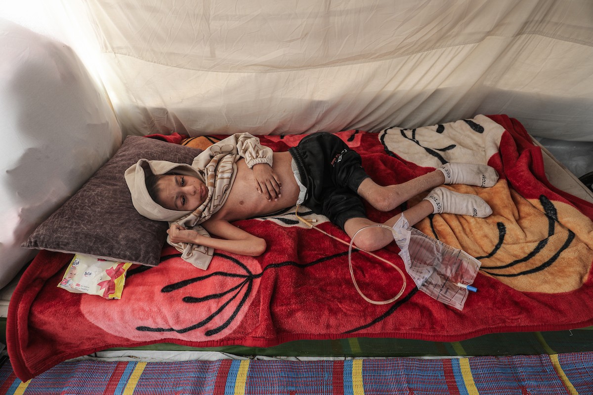 الطفل سيف رامي حجازي (13 عاما) أُصيب بشلل كامل وفشل كلوي إثر قصف إسرائيلي لخيمة عائلته، وتتولى والدته رعايته في ظروف إنسانية بالغة الصعوبة بمخيم المغازي، وسط قطاع غزة، 30 يناير/كانون الثاني 2026. صورة: معز صالحي