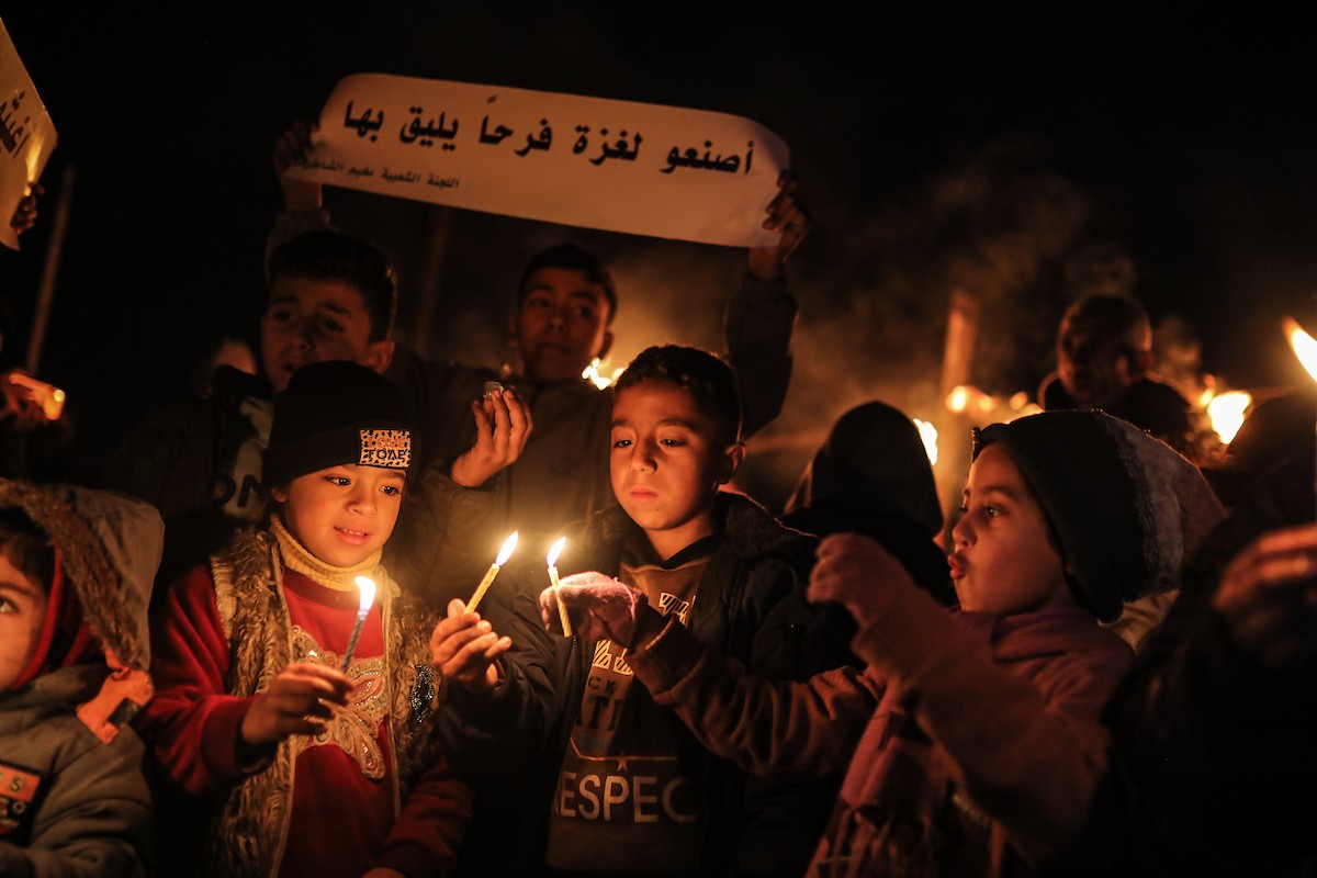 أطفال في وقفة احتجاجية في مخيم الشاطئ غرب مدينة غزة ليلة رأس السنة الميلادية 2026، 1 يناير/كانون الثاني 2026. تصوير: عمر أشتوي