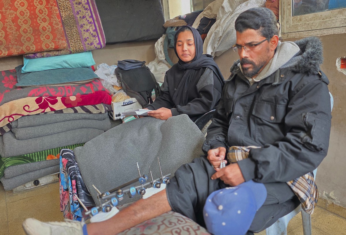 ريماس أبو لحية ووالدها مصابان بساقيهما برصاص الجيش الإسرائيلي، وينتظران السفر لاستكمال العلاج خارج قطاع غزة، خان يونس، 25 يناير/كانون الثاني 2026. تصوير: طارق محمد/ (APA Images)