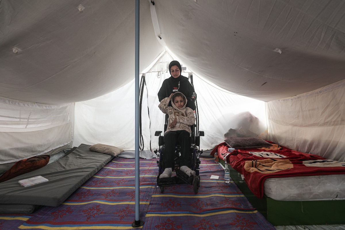 الطفل سيف رامي حجازي (13 عاما) أُصيب بشلل كامل وفشل كلوي إثر قصف إسرائيلي لخيمة عائلته، وتتولى والدته رعايته في ظروف إنسانية بالغة الصعوبة بمخيم المغازي، وسط قطاع غزة، 30 يناير/كانون الثاني 2026. صورة: معز صالحي