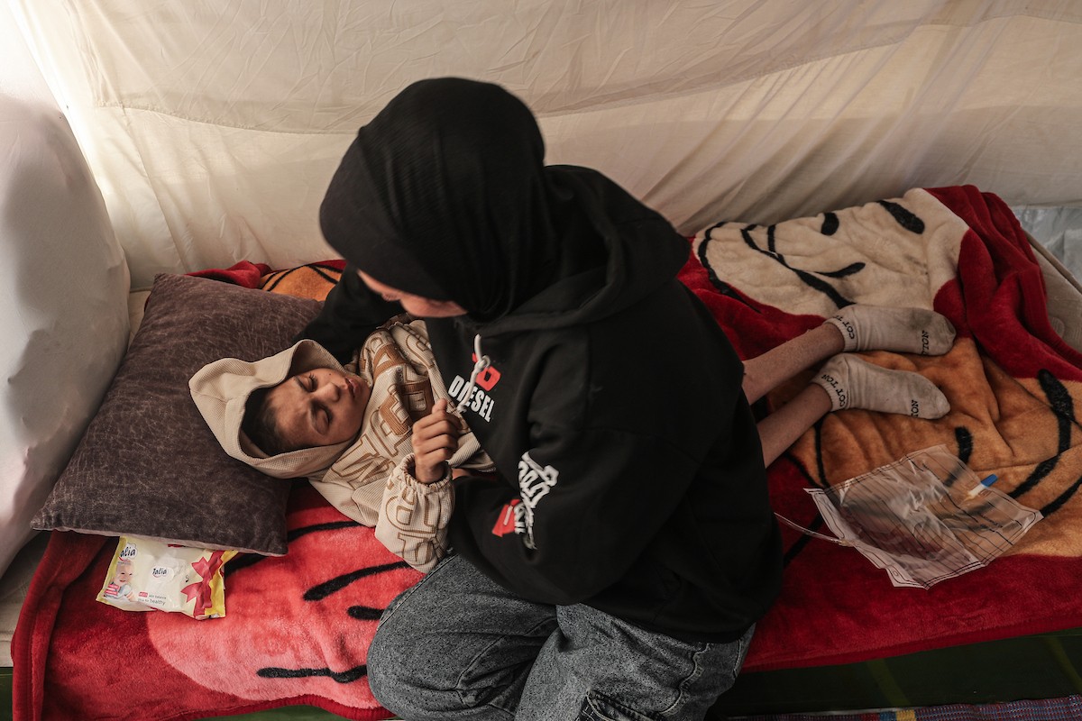 الطفل سيف رامي حجازي (13 عاما) أُصيب بشلل كامل وفشل كلوي إثر قصف إسرائيلي لخيمة عائلته، وتتولى والدته رعايته في ظروف إنسانية بالغة الصعوبة بمخيم المغازي، وسط قطاع غزة، 30 يناير/كانون الثاني 2026. صورة: معز صالحي