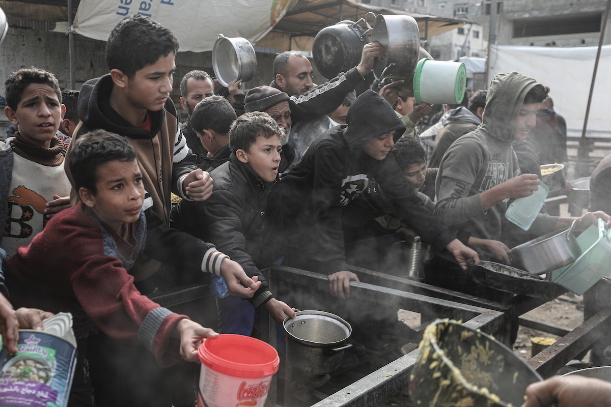 تجمع فلسطينيون نازحون داخلياً في مطبخ خيري لتلقي حصص غذائية محدودة وسط نقص حاد في الغذاء، في مخيم النصيرات للاجئين وسط قطاع غزة، 21 يناير/كانون الثاني 2026. صورة: معز صالحي