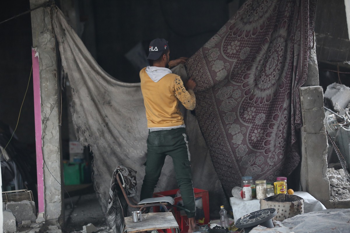 يبحث فلسطينيون عن ممتلكاتهم بين الأنقاض بعد أن دمرت غارات جوية إسرائيلية مبنى في مخيم البريج للاجئين وسط قطاع غزة. دمر الهجوم المبنى بالكامل وألحق أضرارًا بالمنشآت المحيطة به، 9 يناير/كانون الثاني 2026. صورة: معز صالحي